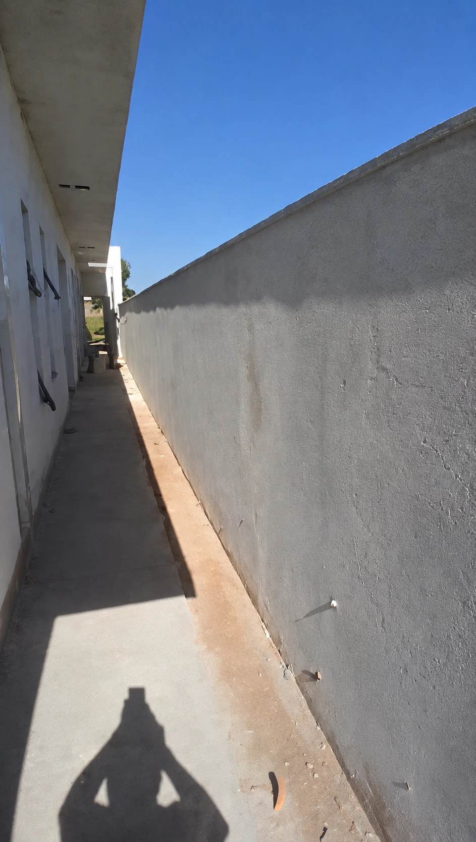 Parede externa clara em corredor lateral descoberto